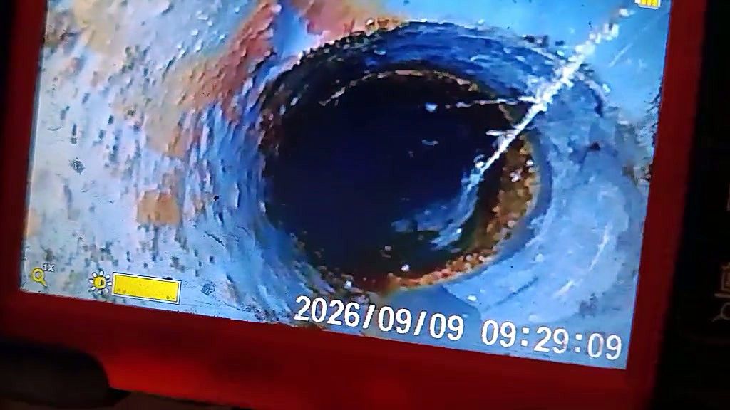 Ekran kamere za kanalizaciju: mlaz vode ulazi u cev kroz pukotinu — snimak Mars 022
