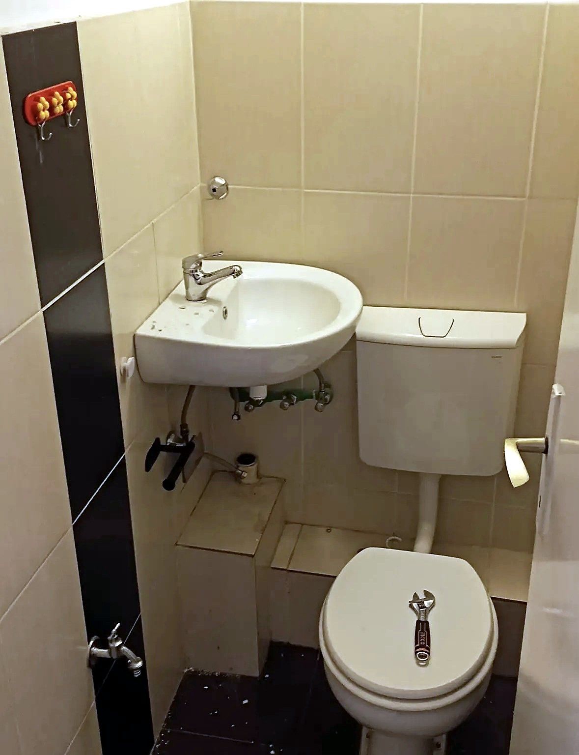 Toalet pre radova: stare pločice, mali lavabo i dotrajali priključci
